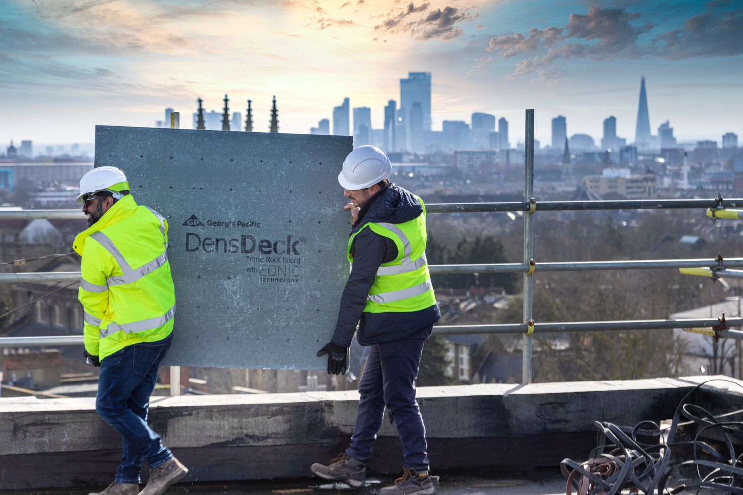 DensDeck Roofboard carried by two  construction workers